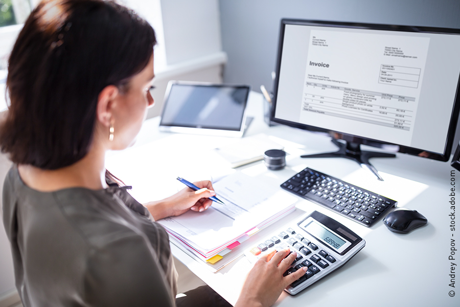 A bookkeeper pays outstanding accounts.
