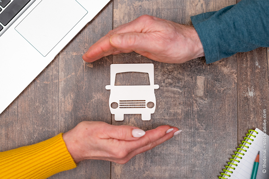woman and man hold hands protectively over truck symbol