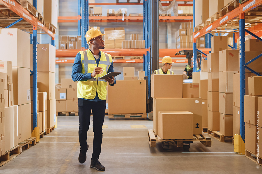 man walking with tablet in a warehouse
