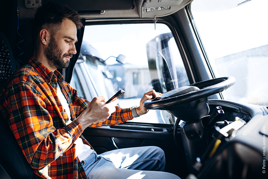 man inside truck watching his cellphone