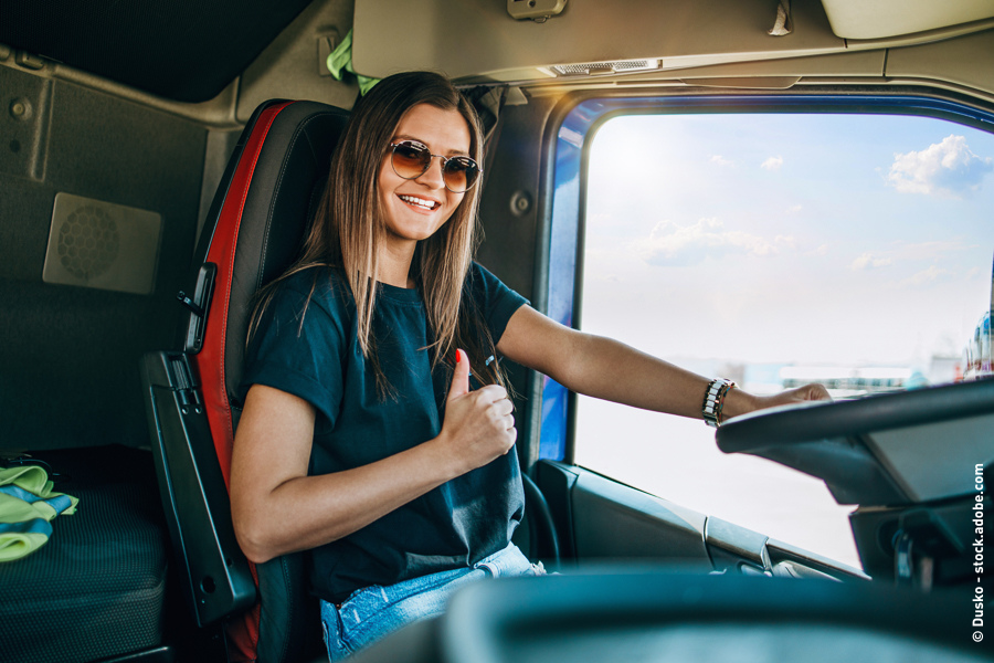 A woman is sitting in a lorry with a smile on her face